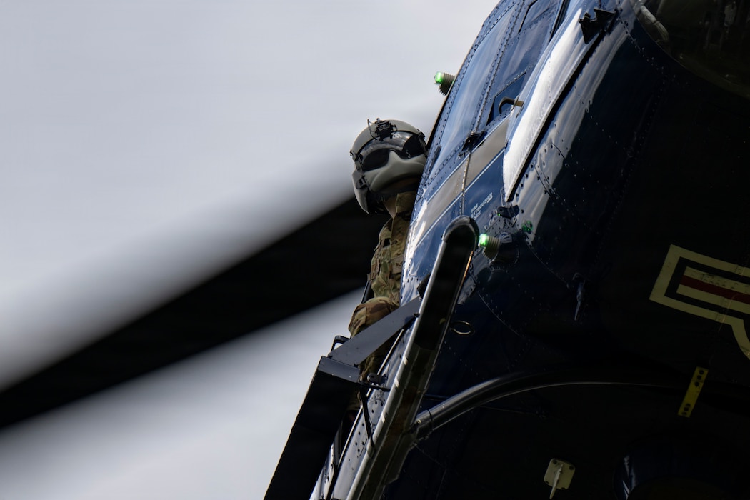 Senior Airman Hayden Tadgerson, 1st Helicopter Squadron UH-1N Huey flight engineer, checks the surrounding area after takeoff.