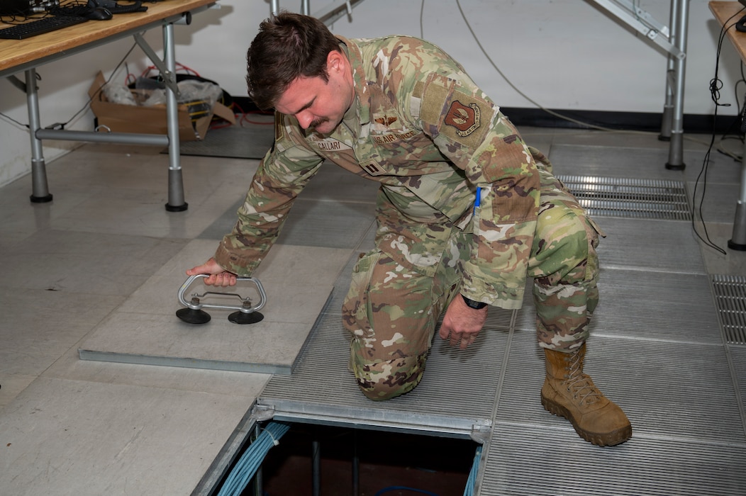 U.S. Air Force Capt. Christopher Callari, 606th Air Control Squadron operations officer in charge, removes a floor panel to run cable in preparation for exercise Astral Knight 2026 at RAF Lakenheath, England, May 27, 2026.