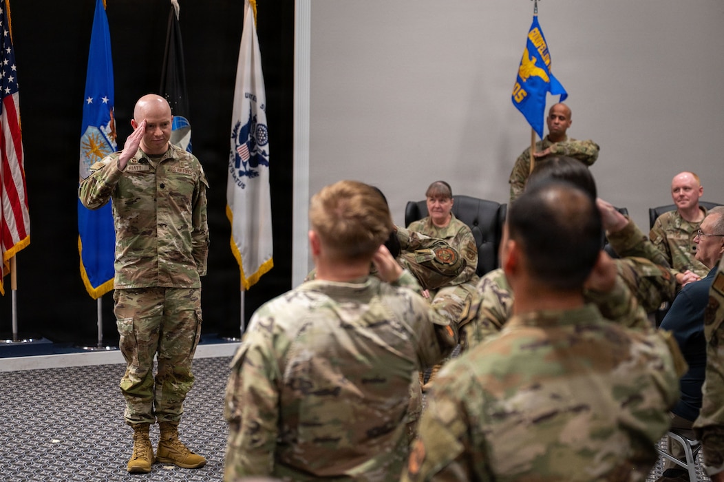 A uniformed service member salutes a formation.