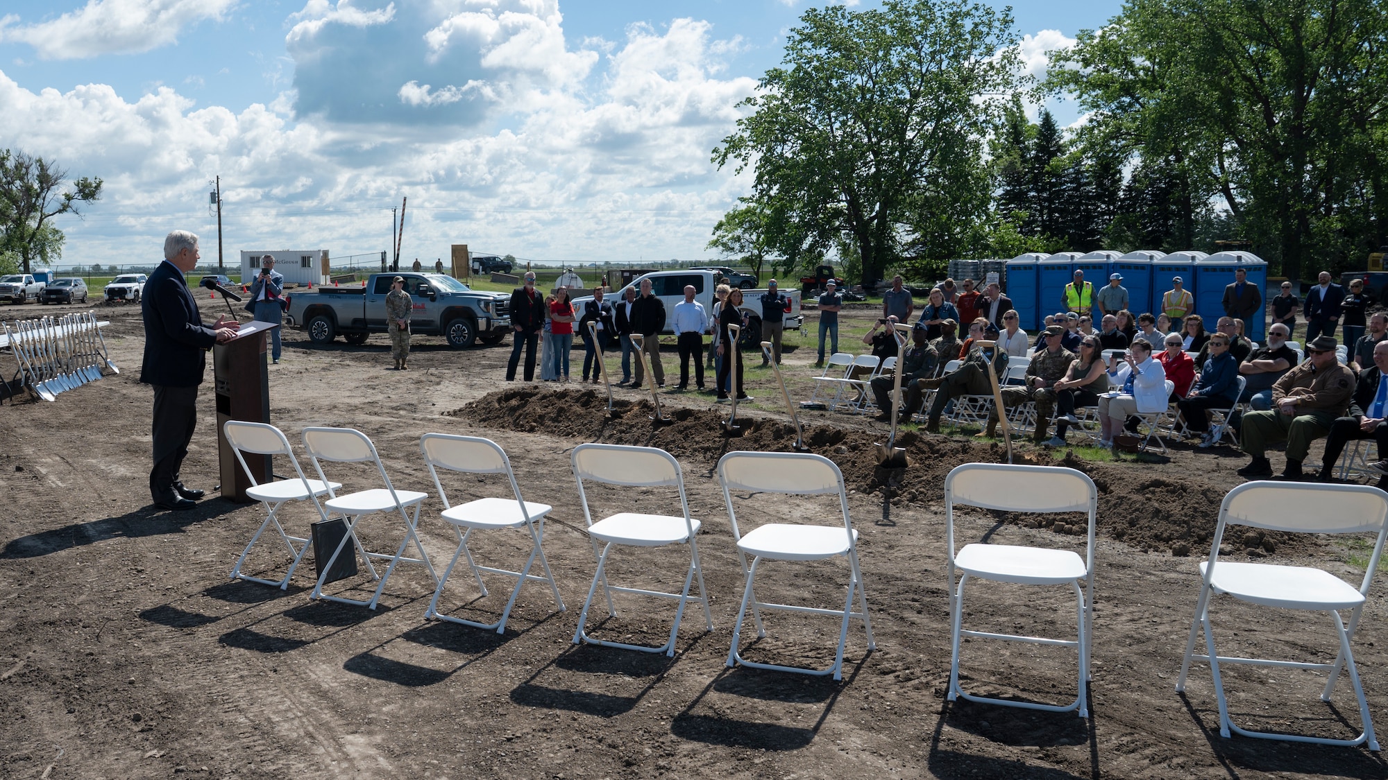 A man speaks to a crowd on a construction site.