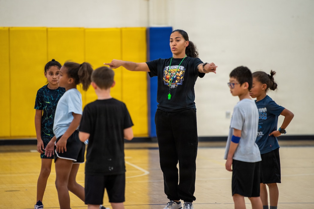 Airman leads youth basketball in stretching exercises