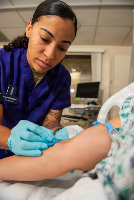 Airman preps needle to draw blood on patient