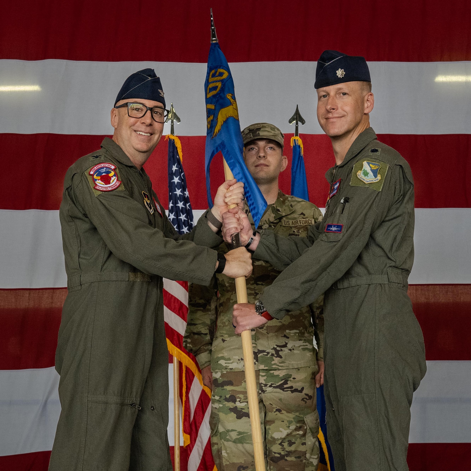 U.S. Air Force Col. Eric Bissonette, 47th Flying Training Wing commander, presents the guidon to Lt. Col. James Hesson, 87th Flying Training Squadron incoming commander, during a change of command ceremony at Laughlin Air Force Base, Texas, June 12, 2026. Change of command ceremonies represent a formal transfer of authority and responsibility for a unit from one commanding officer to another. (U.S. Air Force photo by Airman 1st Class Harrison Sullivan)