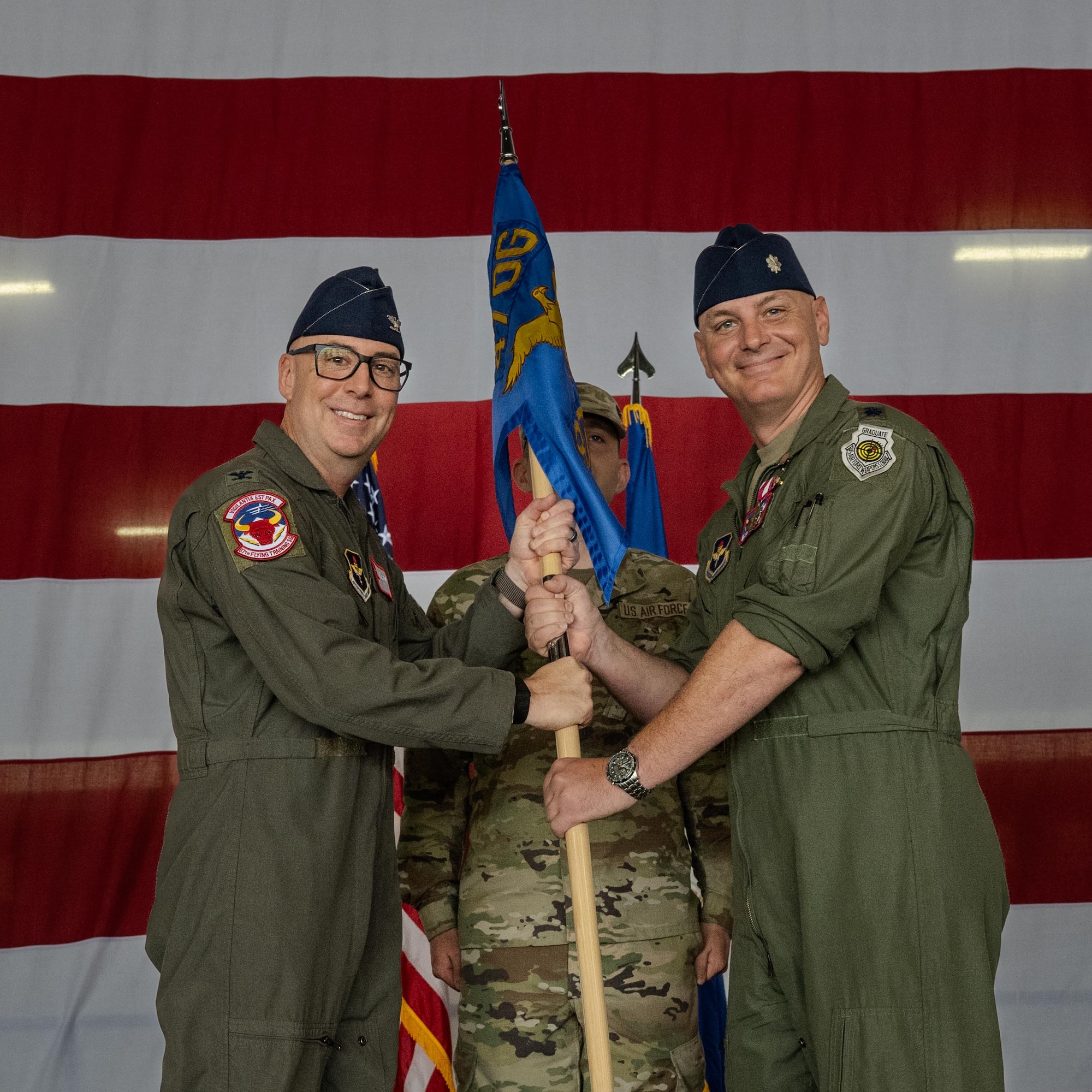 U.S. Air Force Col. Eric Bissonette, 47th Flying Training Wing commander, accepts the guidon from Lt. Col. Johnathan Radtke, 87th Flying Training Squadron outgoing commander, during a change of command ceremony at Laughlin Air Force Base, Texas, June 12, 2026. Change of command ceremonies represent a formal transfer of authority and responsibility for a unit from one commanding officer to another. (U.S. Air Force photo by Airman 1st Class Harrison Sullivan)