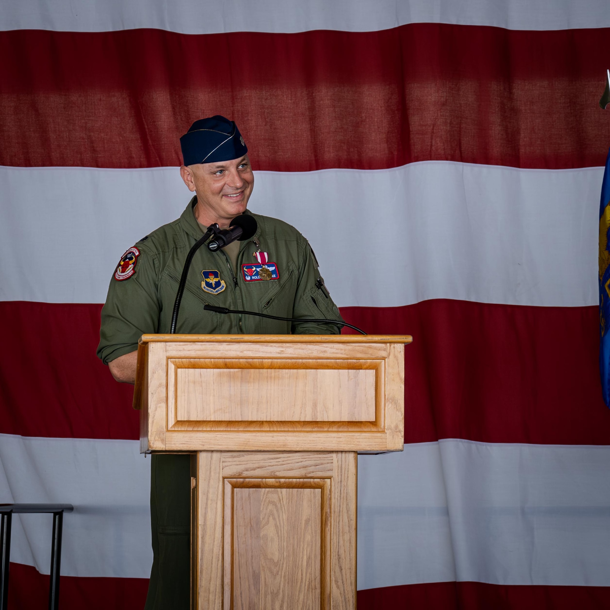U.S. Air Force Lt. Col. Johnathan Radtke, 87th Flying Training Squadron outgoing commander, gives a speech during a change of command ceremony at Laughlin Air Force Base, Texas, June 12, 2026. During his time in command, he oversaw the execution of 18K aircraft and simulator sorties and 7.2K academic events; responsible for the readiness and execution of daily flying operations for 71 aircrew, 11 support personnel, 63 aircraft worth $409M, and annually producing over 100 fighter and bomber pilots for the Combat Air Force. (U.S. Air Force photo by Airman 1st Class Harrison Sullivan)