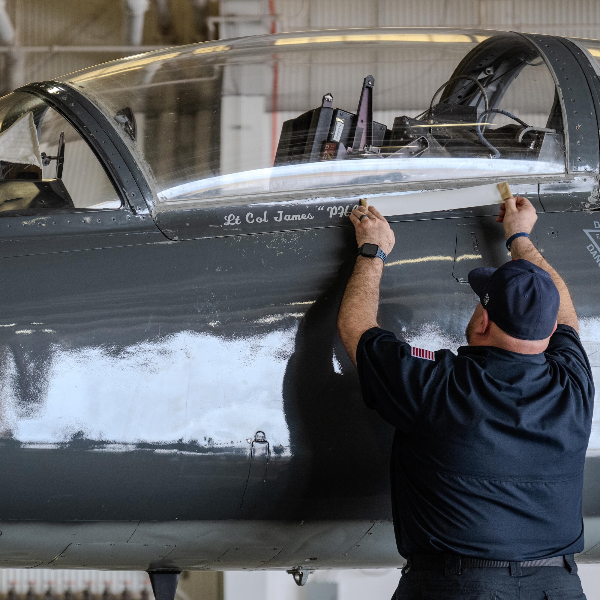 Tomas Cienega, 47th Maintenance Directorate dedicated crew chief, reveals Lt. Col. James Hesson’s name on the 87th Flying Training Squadron flagship during the 87th FTS change of command ceremony at Laughlin Air Force Base, Texas, June 12, 2026. Hesson accepted the role as the 87th FTS commander from former commander Lt. Col. Jonathan Radtke. (U.S. Air Force photo by Airman 1st Class Harrison Sullivan)