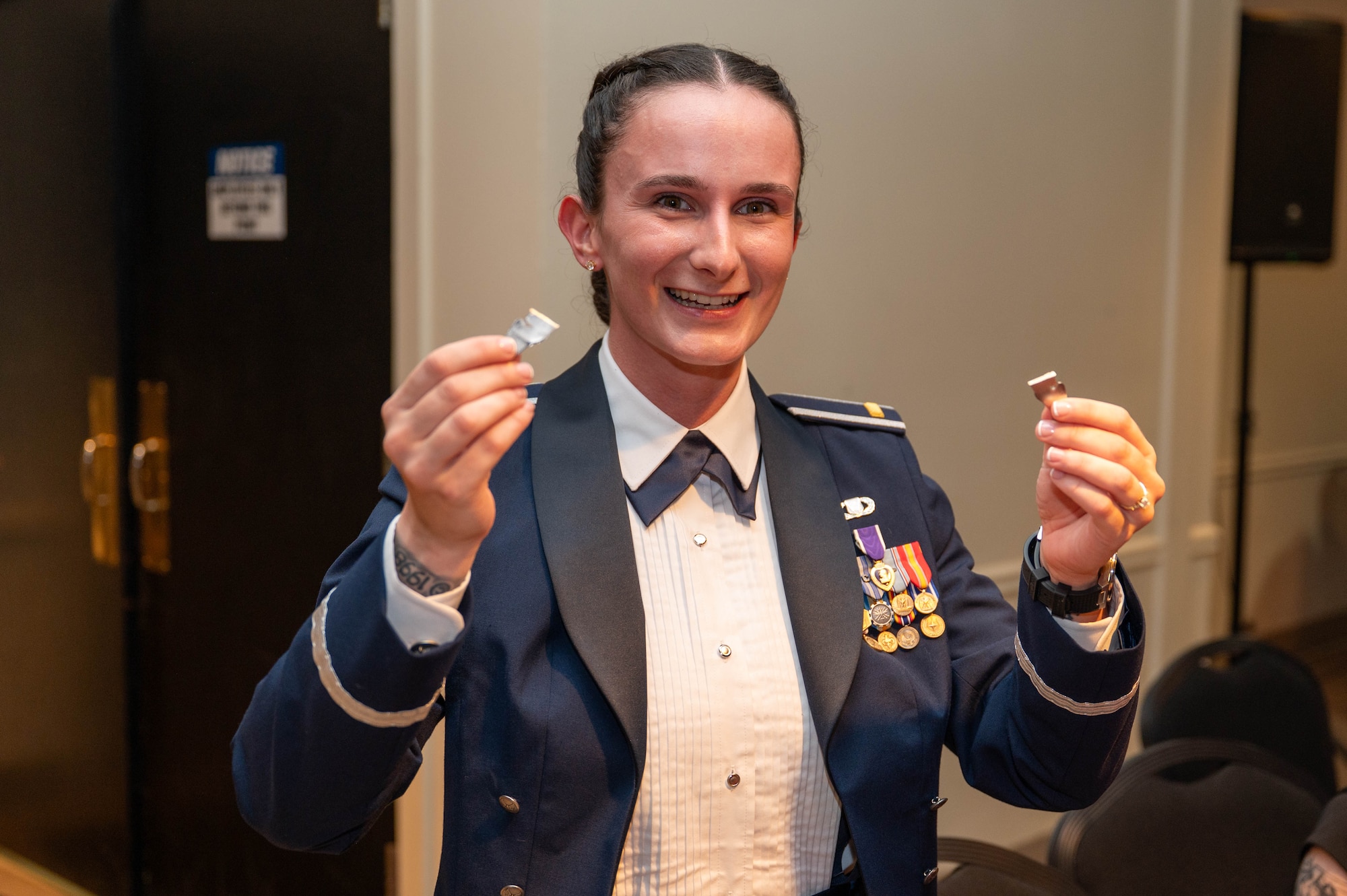 A student pilot holds up her broken silver wings.