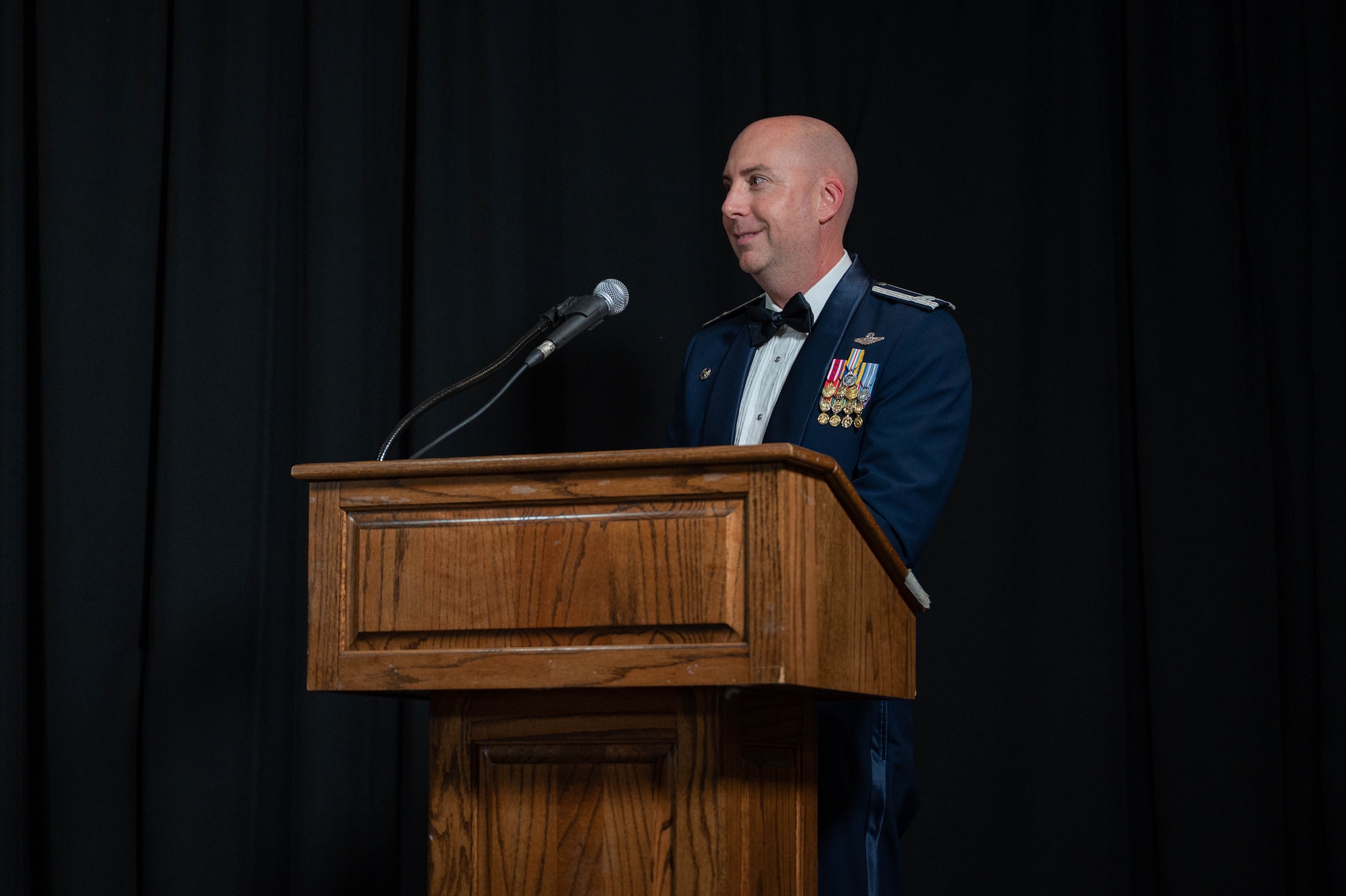 Col. Eric Bissonette gives closing remarks at a podium during a graduation ceremony.