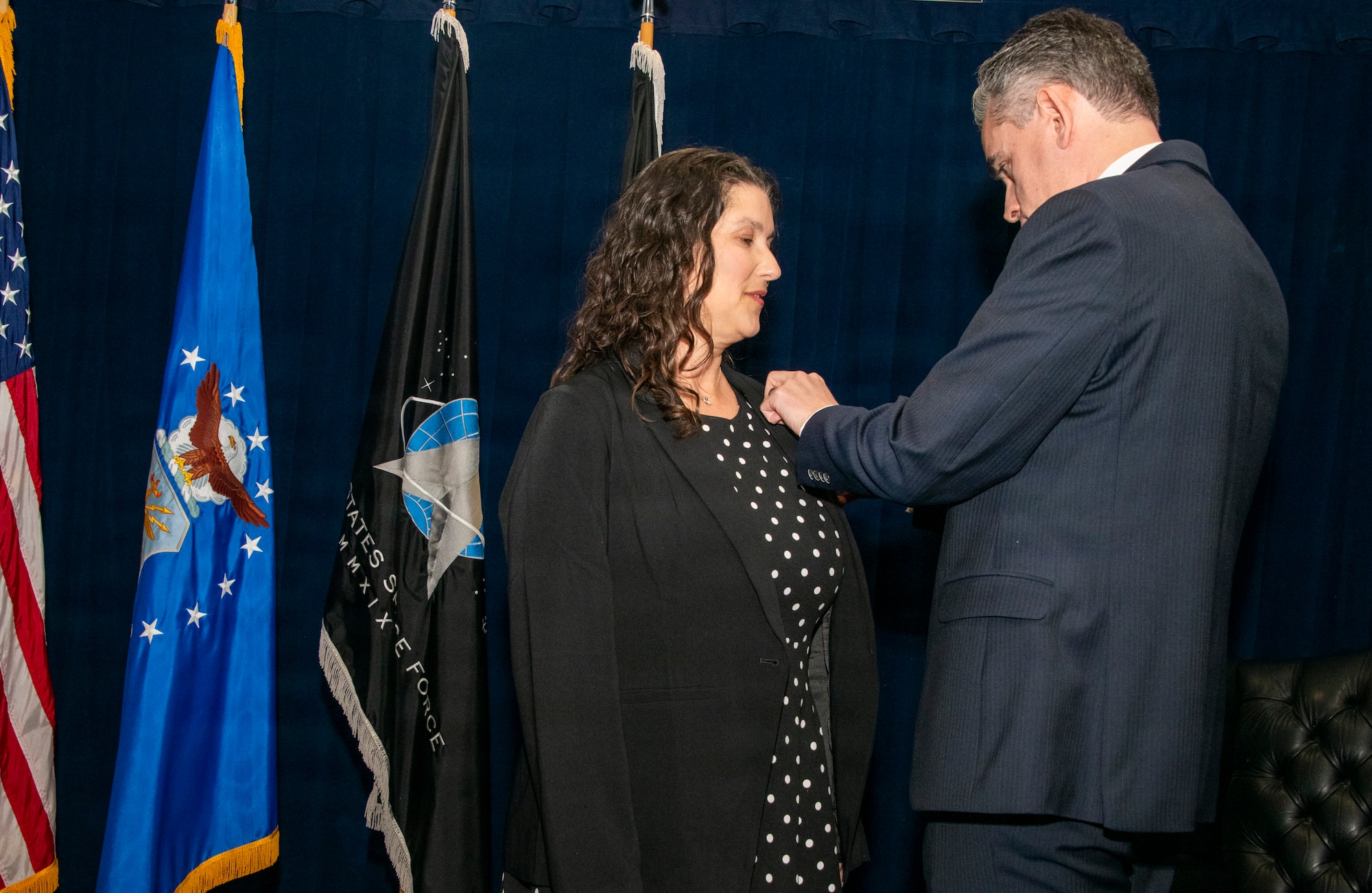 Ms. Shannon Pallone, U.S. Space Force portfolio acquisition executive for the Battle Management, Command, Control, Communication, and Space Intelligence portfolio of programs, receives her Senior Executive Service pin from her husband Devon Lindeboom during her promotion ceremony May 29, 2026, at Space Systems Command headquarters at Los Angeles Air Force Base in El Segundo, Calif. The pin’s design – a keystone at the center holding an arch in place – signifies Pallone as a central coordinating point between leadership and line workers implementing the Government’s political agenda. (U.S. Space Force Photo: Van Ha)