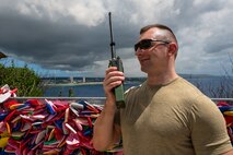 U.S. Air Force Staff Sgt. Marcin Drozd, 439th Aeromedical Evacuation Squadron expeditionary communication technician, communicates over an AN/PRC-163 multi-channel handheld radio during Cyber Guam 2026 in Tamuning, Guam, June 4, 2026.