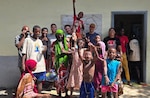Air National Guardsmen take a photo with locals while volunteering at a orphanage during their deployment in Djibouti, Feb. 21. Members of the 130th Airlift Wing set up a medical clinic to assist with wound care for the local populace. (Courtesy Photo)