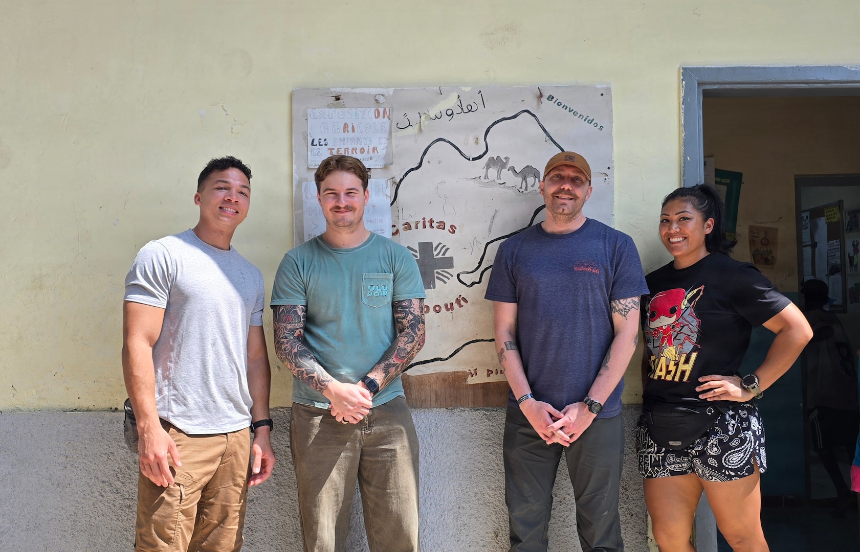 Air National Guardsmen take a photo with locals while volunteering at a orphanage during their deployment in Djibouti, Feb. 21. Members of the 130th Airlift Wing set up a medical clinic to assist with wound care for the local populace.