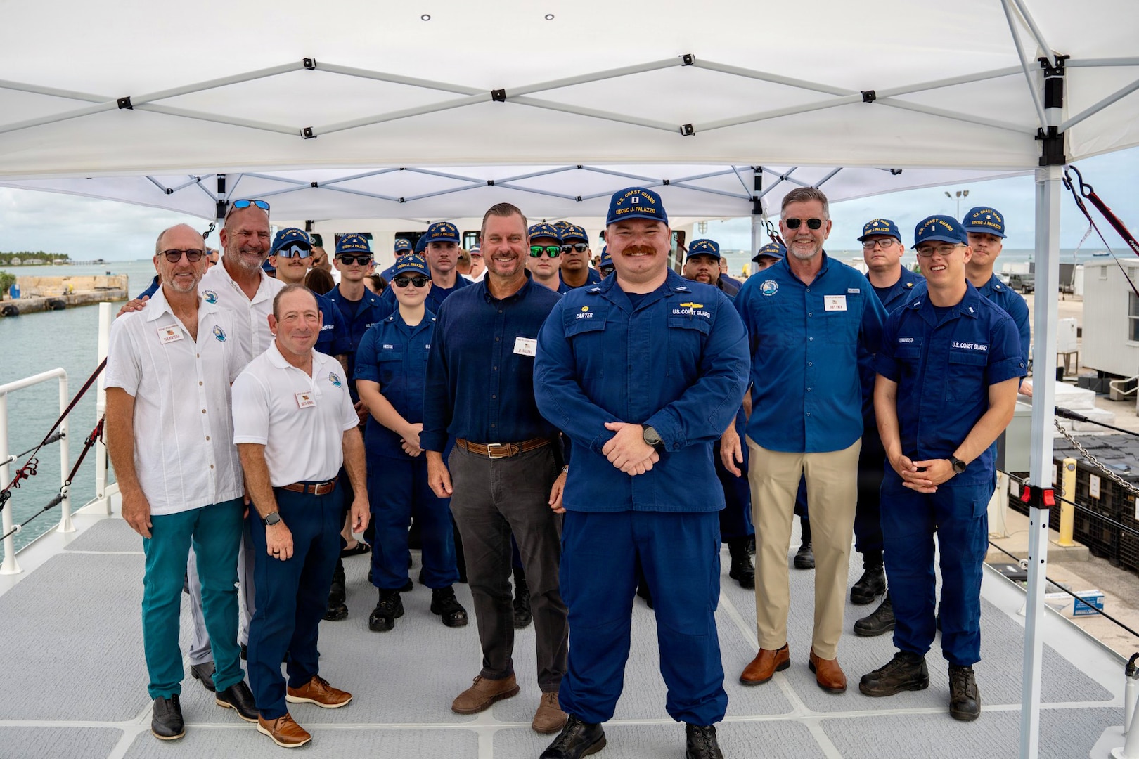 Lt. Hayden Carter, commanding officer of USCGC Jeffrey Palazzo (WPC 1163), Allen Harker, contracting officer for the Fast Response Cutter Project, the crew of the cutter, and guests stand for a photo during an acceptance ceremony in Key West, Florida, on June 11, 2026. The cutter is named for Jeffrey Palazzo, a New York City firefighter and U.S. Coast Guard reservist who made the ultimate sacrifice on Sept. 11, 2001, while responding to the attacks on the World Trade Center. (U.S. Coast Guard photo by Ensign Carly Logan)