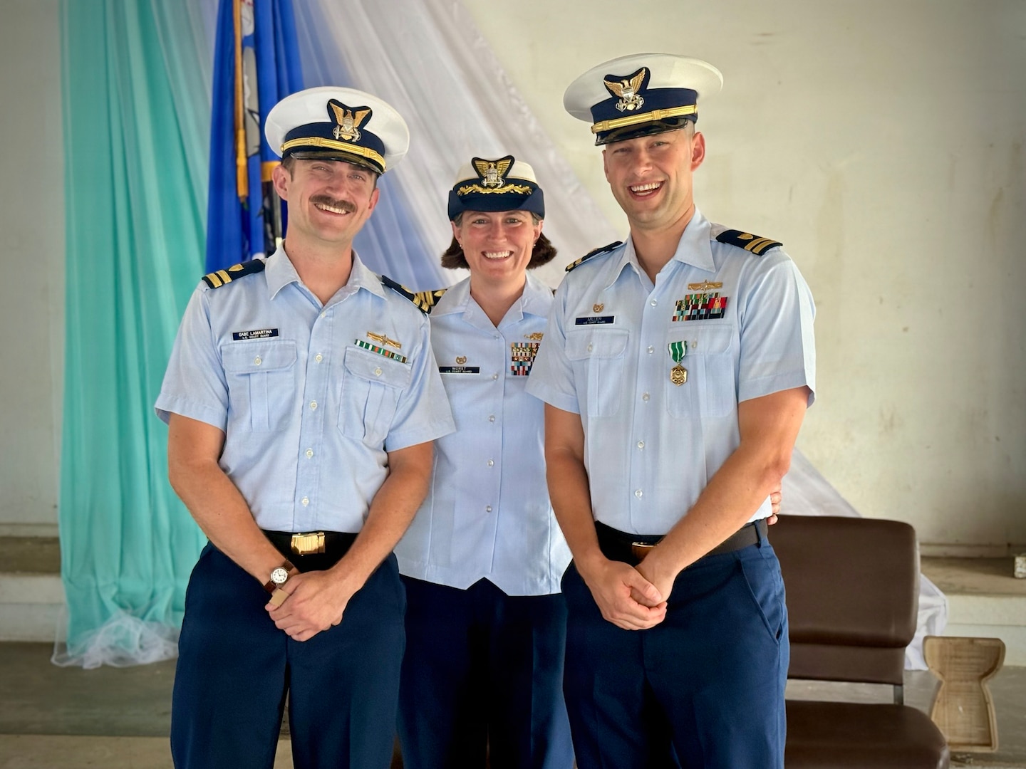 Lt. Gabriel LaMartina (left), Lt. Justin Miller (right), and Capt. Jesica Worst, the presiding official, stand for a photo following a change of command ceremony for Marine Safety Unit Saipan in Saipan, Commonwealth of the Northern Mariana Islands, on June 13, 2026. During Miller's tenure from October 2023 to June 2026, MSU Saipan stood up as a full Marine Safety Unit — elevated from Marine Safety Detachment Saipan on April 5, 2024 — and matured into the Coast Guard's permanent prevention and response presence across the Commonwealth. Under his leadership, the unit advanced maritime safety, security, and environmental stewardship through vessel inspections, port state control examinations, container inspections, and continuous engagement with port partners and local leaders. (U.S. Coast Guard photo by Dee Cruz)
