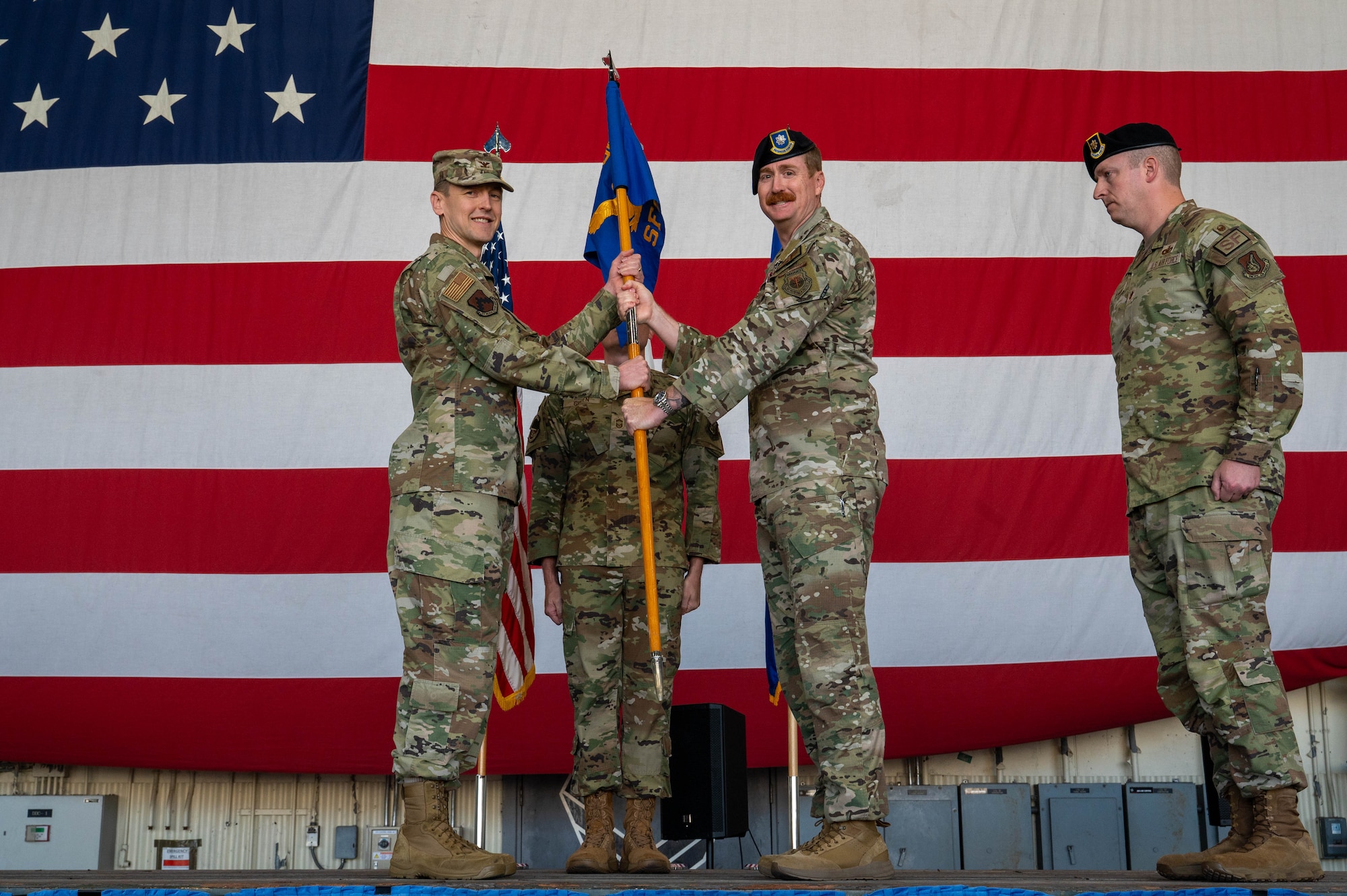 U.S. Air Force Lt. Col. Ryan Kiggings, 8th Security Forces Squadron outgoing commander, center, passes the guidon to U.S. Air Force Col. Timothy Frank, 8th Mission Support Group commander, left, during the 8th Security Forces Squadron change of command ceremony at Kunsan Air Base, Republic of Korea, June 12, 2026. The passing of the guidon symbolizes the preservation of military heritage and the seamless transition of leadership that has strengthened America's armed forces for 250 years. (U.S. Air Force photo by Staff Sgt. Cedrique Oldaker)