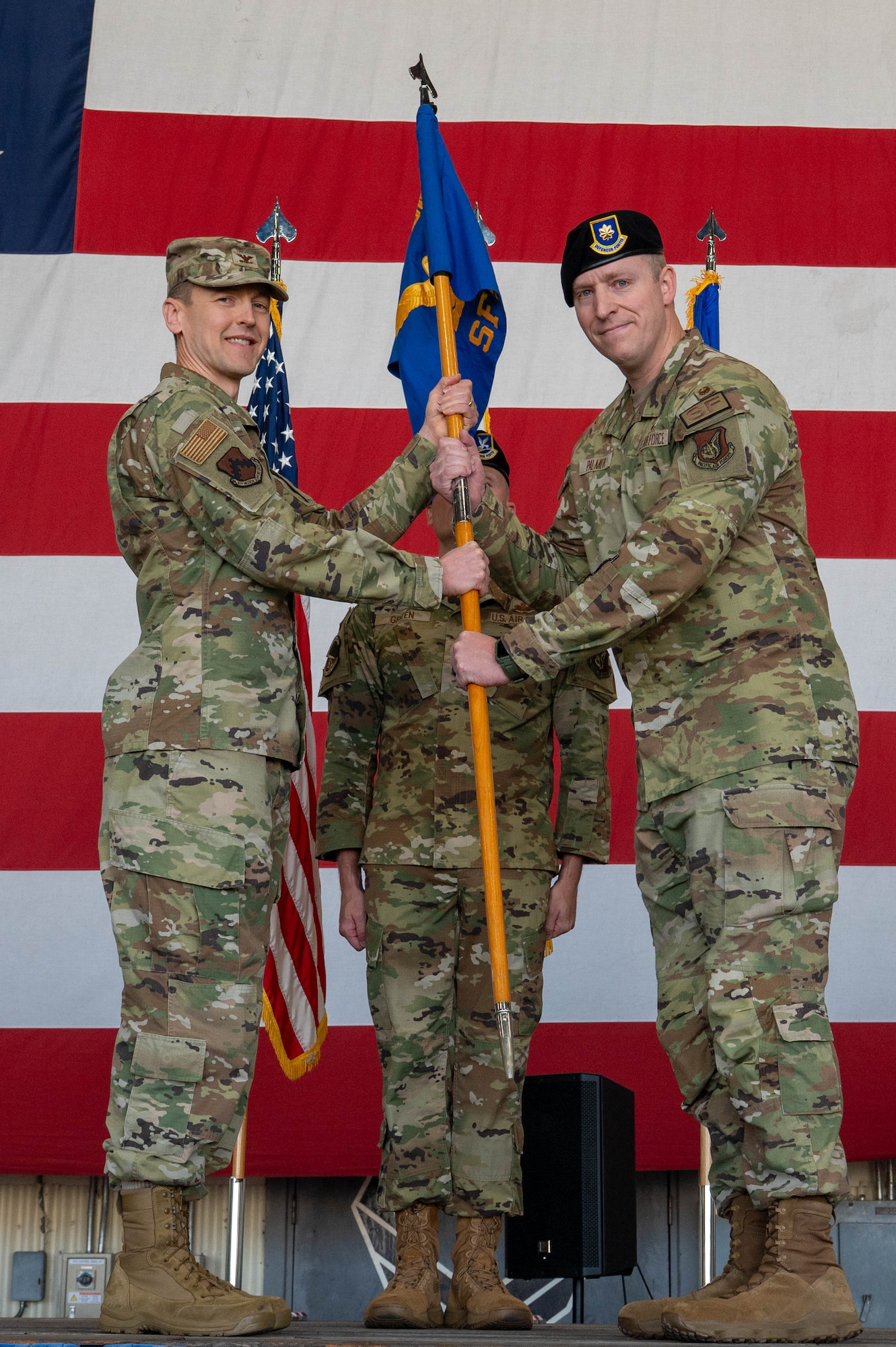 U.S. Air Force Maj. Adam Palmer, 8th Security Forces Squadron incoming commander, right, receives the guidon from U.S. Air Force Col. Timothy Frank, 8th Mission Support Group commander, left, during the 8th SFS change of command ceremony at Kunsan Air Base, Republic of Korea, June 12, 2026. The passing of the guidon symbolizes the preservation of military heritage and the seamless transition of leadership that has strengthened America's armed forces for 250 years. (U.S. Air Force photo by Staff Sgt. Cedrique Oldaker)