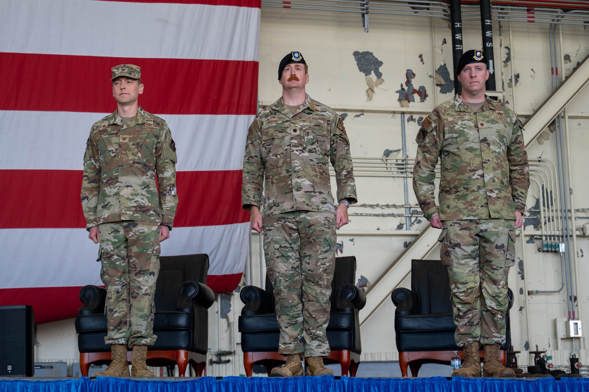 U.S. Air Force members Col. Timothy Frank, 8th Mission Support Group commander, left, Lt. Col. Ryan Kiggins, 8th Security Forces Squadron outgoing commander, middle, and Maj. Adam Palmer, 8th SFS incoming commander, stand at attention for the national anthem during the 8th SFS change of command ceremony at Kunsan Air Base, Republic of Korea, June 12, 2026. The event recognized the outgoing commander's service while welcoming the incoming commander to the unit. (U.S. Air Force photo by Staff Sgt. Cedrique Oldaker)