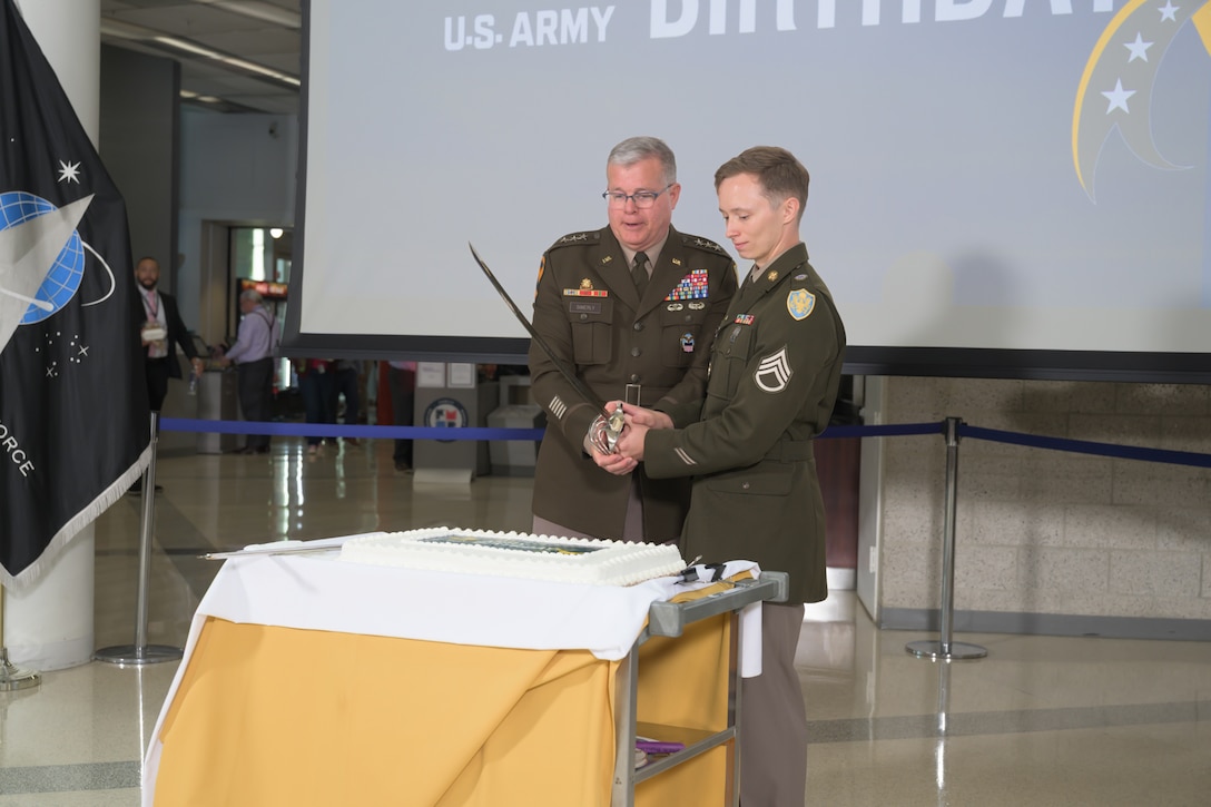 Two Army soldiers cut a cake for the services' 251st birthday.