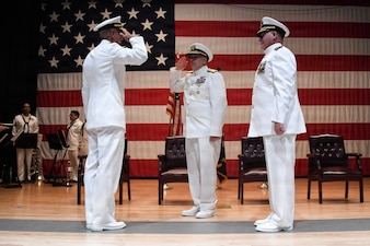 Incoming Commander Capt. Afshin Afarin, left, salutes Rear Admiral Matthew Case, Deputy Navy Surgeon General, during the NMRTC GL change of command ceremony June 12 at the Capt. James A. Lovell Federal Health Care Center in North Chicago, Ill. To the right stands outgoing Commander Capt. Chad Roe, who, in a separate ceremony following the change of command, retired after 30 years of service.