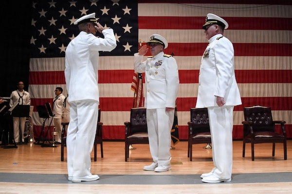 Incoming Commander Capt. Afshin Afarin, left, salutes Rear Admiral Matthew Case, Deputy Navy Surgeon General, during the NMRTC GL change of command ceremony June 12 at the Capt. James A. Lovell Federal Health Care Center in North Chicago, Ill. To the right stands outgoing Commander Capt. Chad Roe, who, in a separate ceremony following the change of command, retired after 30 years of service.