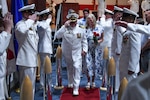 Navy Capt. Chad Roe escorts his wife, Pam Roe, 