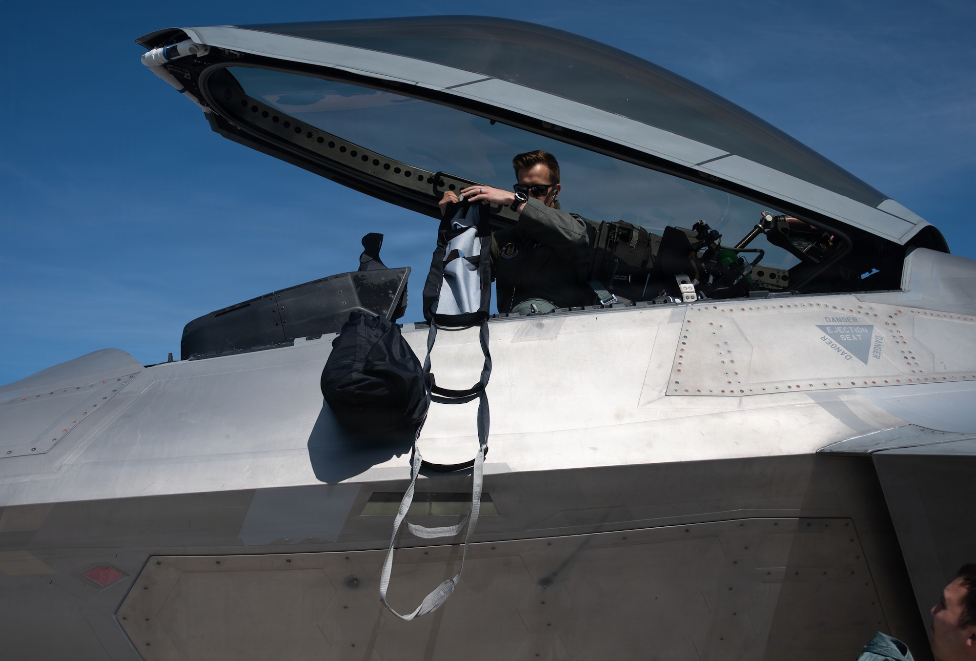 Pilot pulls ladder into aircraft cockpit.
