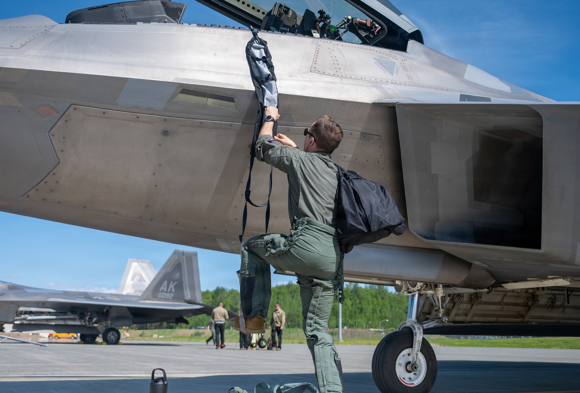 Pilot climbs into aircraft.