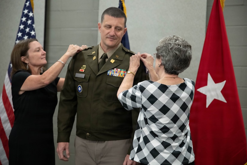 U.S. Army Lt. Col. Michael Sharp is pinned with his new rank by his wife and his mother during a promotion ceremony at the Boone National Guard Center in Frankfort, April 24.