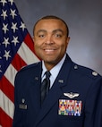 photo of US Air Force Airman standing in front of a US flag