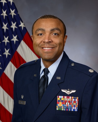 photo of US Air Force Airman standing in front of a US flag