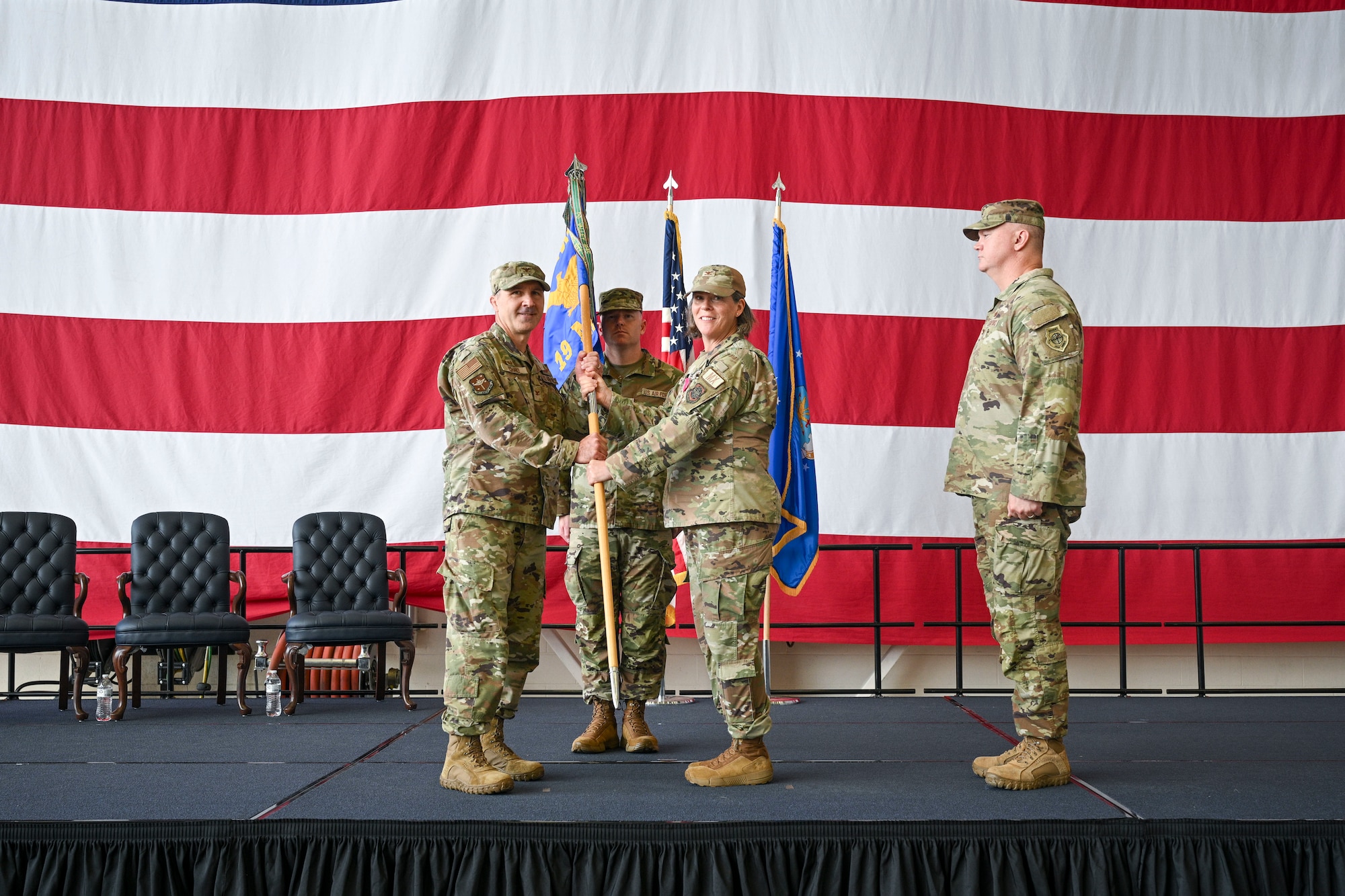 U.S. Air Force Col. Bret Echard accepts a guidon from Col. Amanda Sheets during a change of command ceremony.
