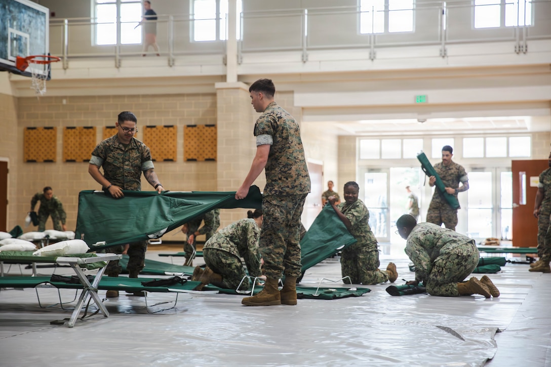 U.S. Marines with Headquarters and Support Battalion, Marine Corps Installations East-Marine Corps Base Camp Lejeune, set up cots inside the destructive weather shelter at the Wallace Creek Fitness Center as part of the Carolina Breeze Destructive Weather Exercise, at MCB Camp Lejeune, North Carolina, June 10, 2026. MCB Camp Lejeune held the Carolina Breeze DWX to test the base’s emergency response capabilities in order to promote flexibility and readiness during the Atlantic hurricane season, which runs from June 1 to November 30. (U.S. Marine Corps photo by Daniela Chicas Torres)