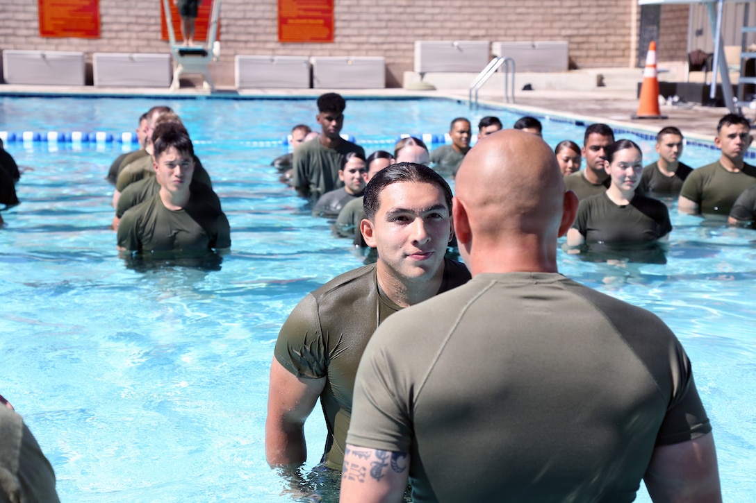 U.S. Marine Corps Sgt. Jorge D. Bosquez and Cpl. Angel F. Cazares reenlist through the Commandant’s Retention Program at the Oasis Pool aboard Marine Corps Logistics Base Barstow, California, June 12. The CRP is designed to retain the Marine Corps' top-performing First Term Marines by offering early reenlistment opportunities.