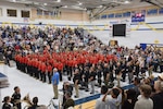 Graduates in a gym during the commencement ceremony
