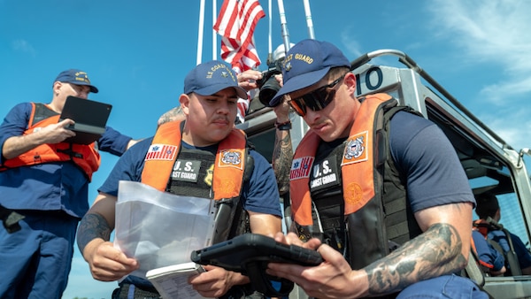 Petty Officer 2nd Class Fabian Monarrez and Petty Officer 2nd Class Merrit Carter use TRITON to conduct a boarding inspection during a live demonstration in Washington on May 19, 2026.  Developed by MLE and CG-RAPTOR, TRITON is a voice-activated iPad application that speeds the boarding process. If testing goes well, could be rolled out to the fleet in fall.