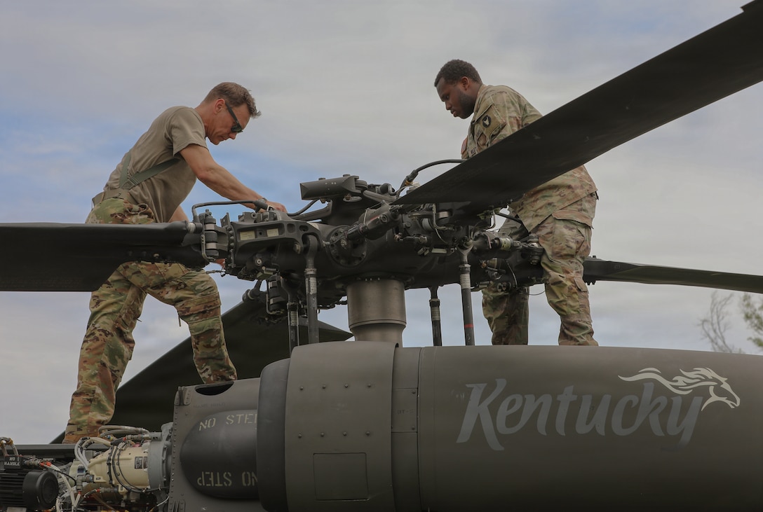 Chief Warrant Officer 2 Stephen Schmelzer (left) and Spc. Ishmael Wilson (right), assigned to Bravo Company, 2nd Battalion, 147th Assault Helicopter Battalion, conduct a pre-flight inspection of a UH-60 Black Hawk helicopter in support of air movement operations and Defense Security Cooperation Agency mission requirements at Muscatatuck Urban Training Center in Butlerville, Indiana, June 1, 2026.