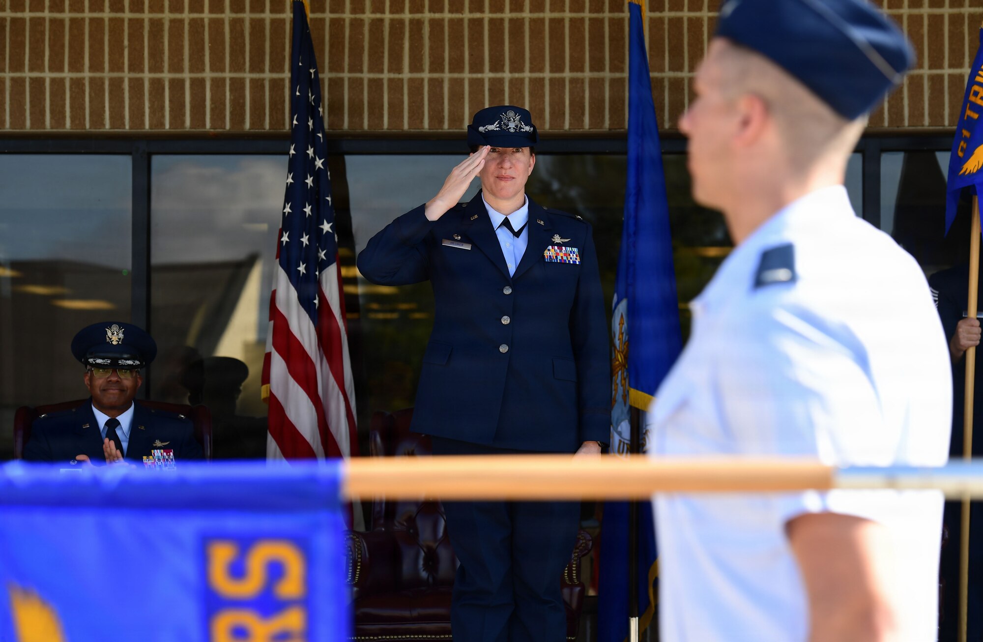 A woman in an Air Force uniform returns a salute to an Airmen.