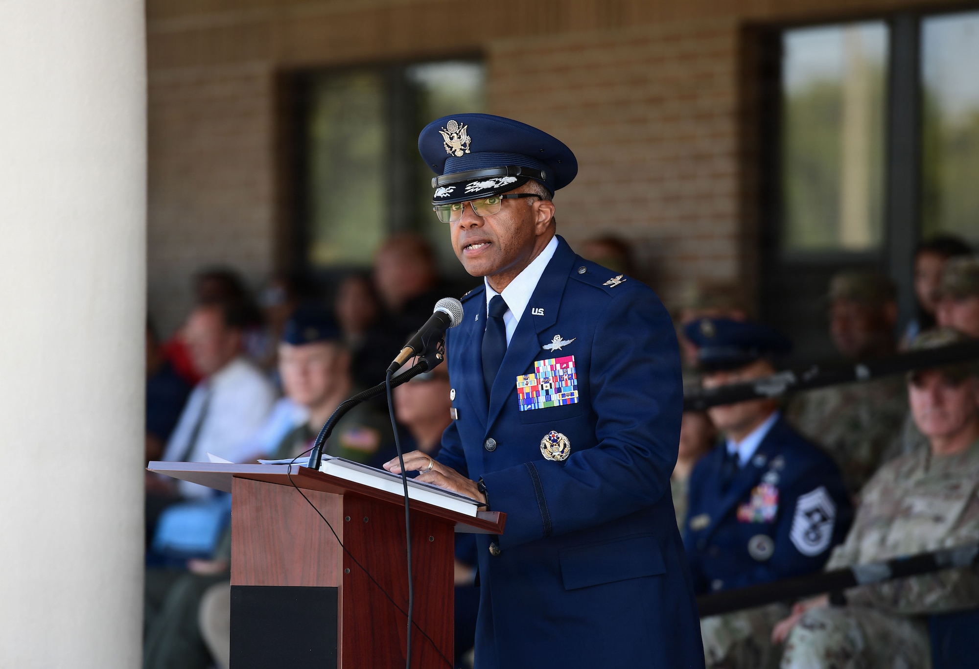 A man in military uniform speaks from behind a podium.