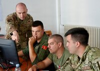 Maine Air National Guard Warrant Officer 1 Zachary Watkins, a white cell member, shows cyber specialists on the blue team from Montenegro’s Ministry of Defense during Combined Adriatic Cyber Endeavor 2026 at the Petar Zrinski Barracks, June 8, 2026.