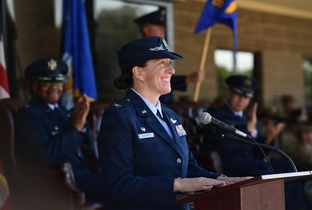 A woman in military uniform speaks from behind a podium.