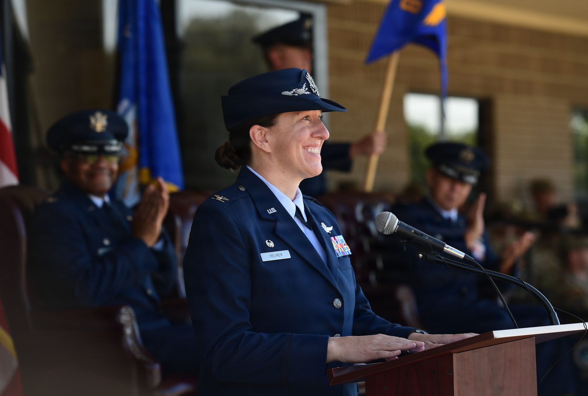 A woman in military uniform speaks from behind a podium.
