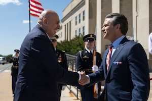 A U.S. and an Italian leader shakes hands in front of the Pentagon.