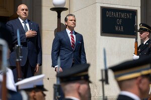 Two men stand at attention during a ceremony at the Pentagon.