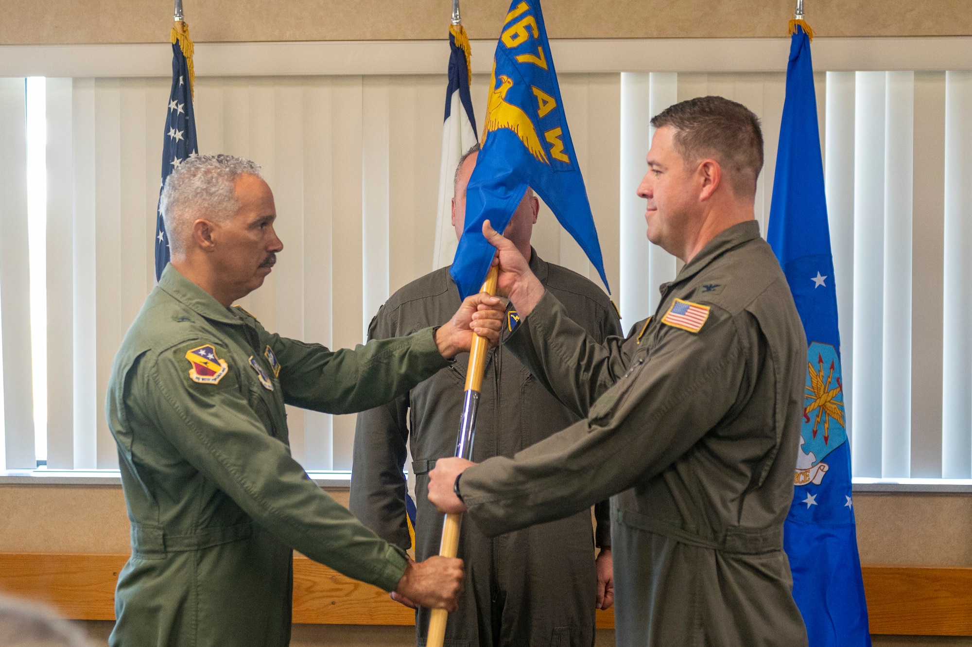 two men hold onto the pole of a flag