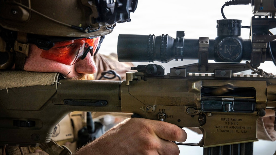 U.S. Marine Corps Sgt. Joseph Garvis, an assistant team leader  with the Maritime Raid Force, 11th Marine Expeditionary Unit, fires an M110 semi-automatic sniper system aboard a UH-1Y Venom assigned to Marine Medium Tiltrotor Squadron (VMM) 163 (Reinforced), 11th MEU, during aerial sniper training in the South China Sea, June 12, 2026. The 11th MEU, embarked aboard the Boxer Amphibious Ready Group, is a persistent, combat credible force contributing to deterrence and crisis response in the U.S. 7th Fleet area of operations. U.S. 7th Fleet, the U.S. Navy's largest forward-deployed numbered fleet, routinely interacts and operates with allies and partners to preserve a free and open Indo-Pacific. (U.S. Marine Corps photo by Sgt. Trent A. Henry)