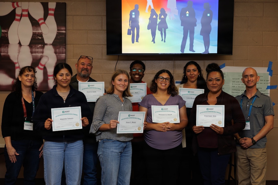 Attendees of the Applied Suicide Intervention Skills Training, pose for a photo with their certificate after completing the ASIST program at Marine Corps Base Camp Pendleton, Calif., June 10, 2026. The LivingWorks ASIST program is a two-day interactive workshop course designed to equip anyone with the necessary skills to provide suicide first aid. Participants learn to recognize risk, intervene to ensure safety and build collaborative safety plans through the course. (U.S. Marine Corps photo by Pfc. Cantu)