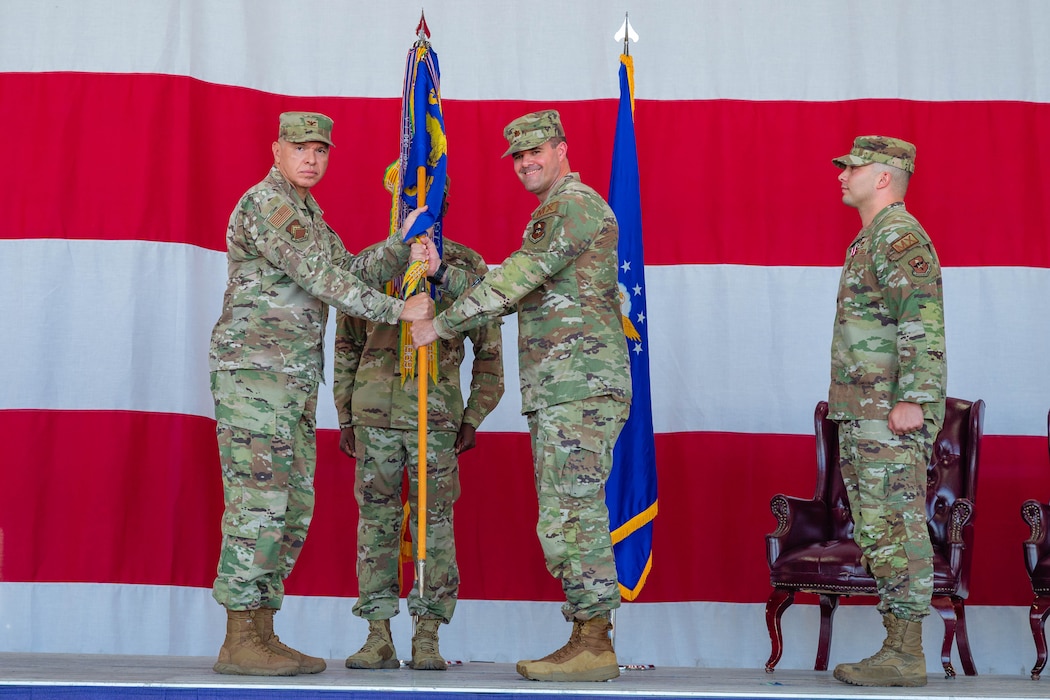 U.S. Air Force Col. Edward Romero, 56th Maintenance Group commander, passes the guidon to Maj. Randy Garner, incoming 56th Component Maintenance Squadron commander, at Luke Air Force Base, Arizona, June 15, 2026.