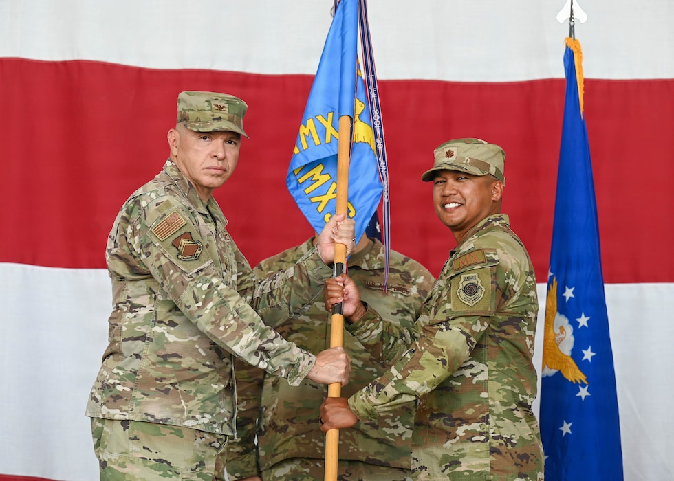 U.S. Air Force Col. Edward Romero, 56th Maintenance Group commander, passes the guidon to Maj. David-Zacharie Sellona, incoming 756th Aircraft Maintenance Squadron commander, at Luke Air Force Base, Arizona, June 12, 2026. The ceremony symbolized the transfer of authority as Sellona assumed command of the squadron, supporting the 56th Fighter Wing’s rapid modernization and advanced F-35A Lightning II training standards, projecting unmatched U.S. power worldwide. (U.S. Air Force photo by Staff Sgt. Magen M. Reeves)