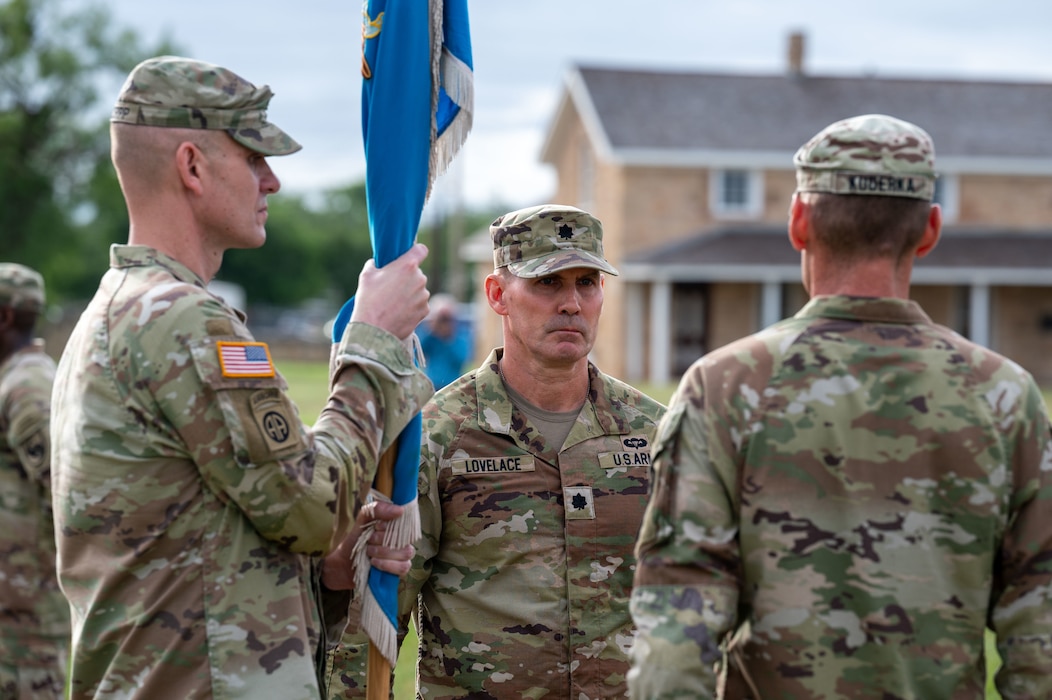 U.S. Army Lt. Col. Jonathan “Matt” Lovelace, incoming 344th Military Intelligence Battalion commander, awaits to receive the battalion guidon from U.S. Army Col. Patrick Schorpp, 111th Military Intelligence Brigade commander, during the change of command ceremony at the Fort Concho parade grounds, San Angelo, Texas, June 12, 2026. Lt. Col. Raymond Kuderka relinquished his duties as commander of the 344th MIB to Lovelace after commanding the Silent Sentinels for two years. (U.S. Air Force photo by Senior Airman James Salellas)