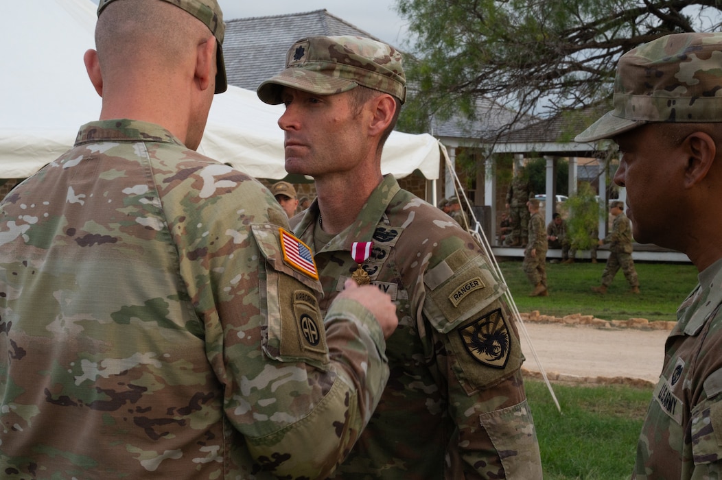 U.S. Army Col. Patrick Schorpp, 111th Military Intelligence Brigade commander, pins the Meritorious Service medal on Lt. Col. Raymond Kuderka, outgoing 344th Military Intelligence Battalion commander, before a change of command ceremony at the Fort Concho parade grounds, San Angelo, Texas, June 12, 2026. Kuderka was awarded the medal for distinguishing himself through outstanding leadership, initiative and impact on the 344th’s Silent Sentinels, the 111th MIB and the 17th Training Wing. (U.S. Air Force photo by Senior Airman Brian Lummus)